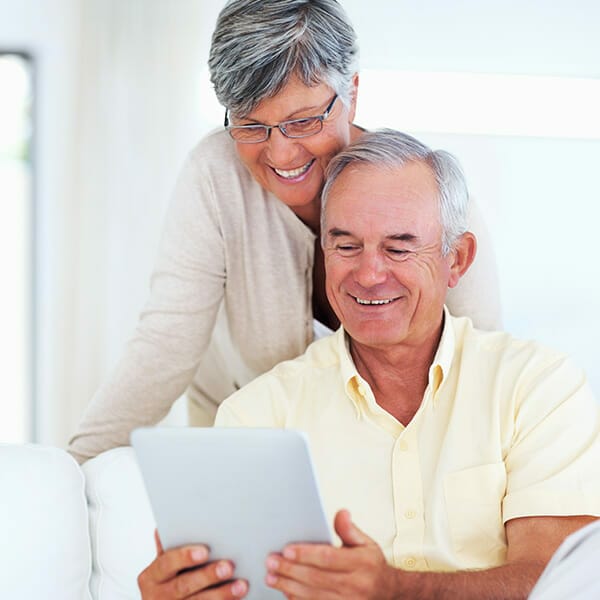 older couple reading ipad because organizations that help cancer patients financially helped them