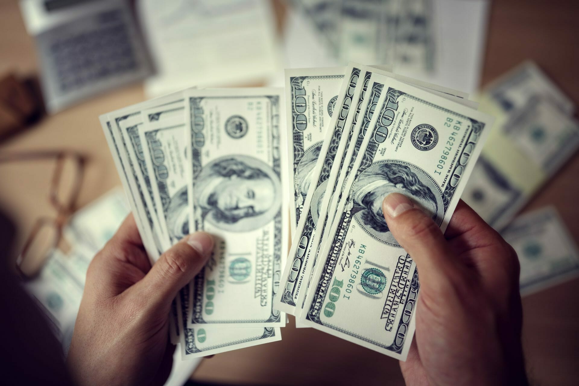 Business man counting savings or payment money with calculator