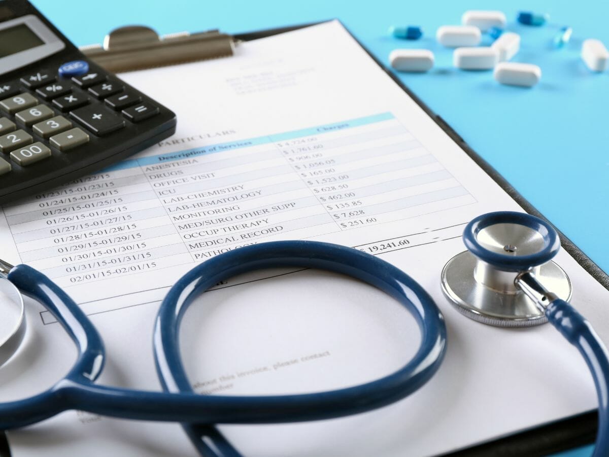 alculator, stethoscope, and medical bill on a clipboard, symbolizing financial aid for Myelodysplastic Syndromes (MDS) patients.