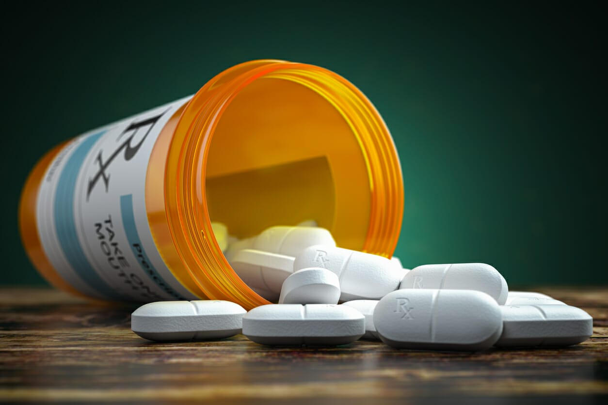 Prescription bottle with spilled pills, representing financial aid for Myelodysplastic Syndromes (MDS) patients.