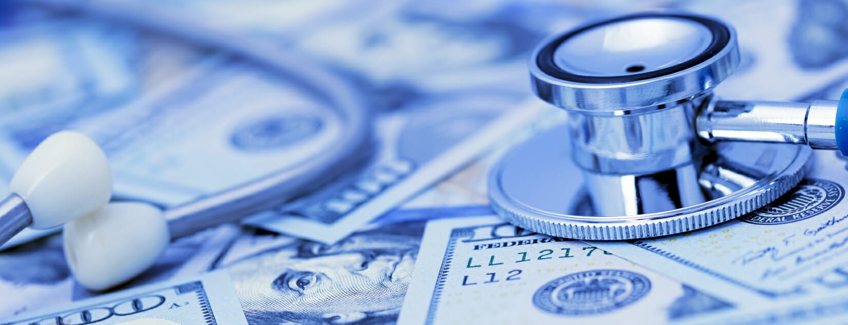 Stethoscope on hundred-dollar bills, symbolizing the financial burden of cancer treatment.