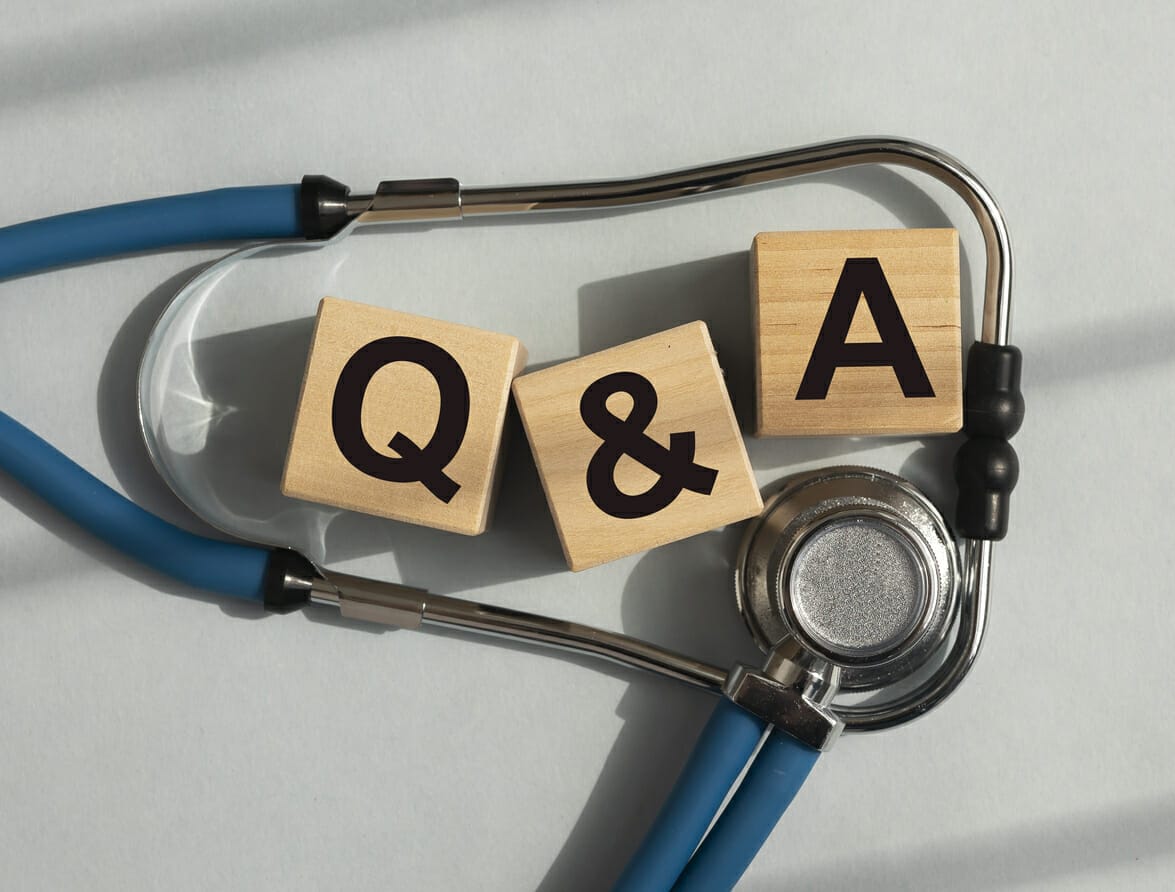 Wooden blocks spelling 'Q & A' on a stethoscope, representing questions and answers about financial assistance for cancer patients in New York.