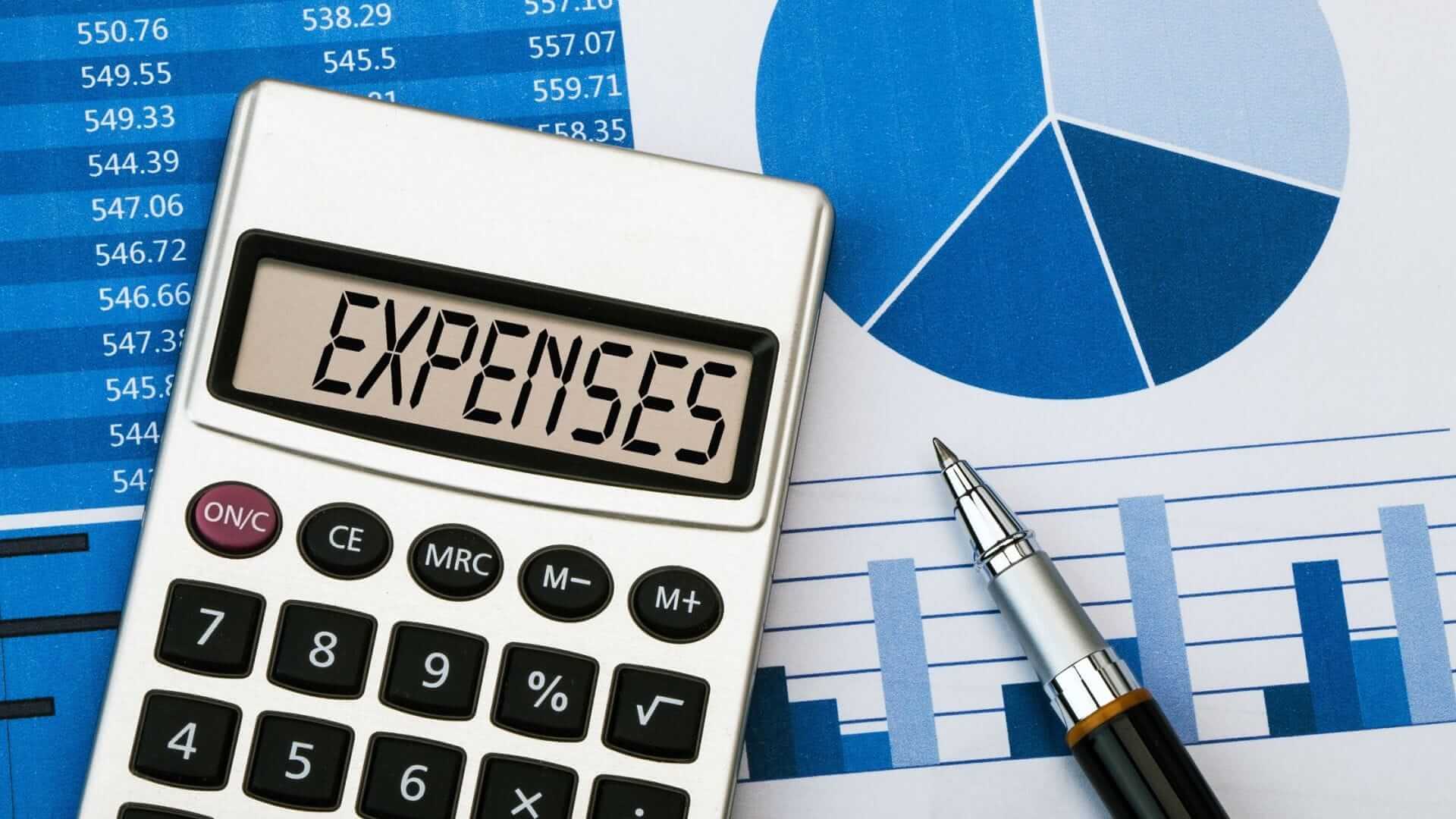 Image of a calculator reading expenses sitting on a graph